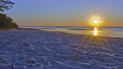 Sunrise over Tampa Bay from a Fort De Soto beach, Skyway Bridge in the distance