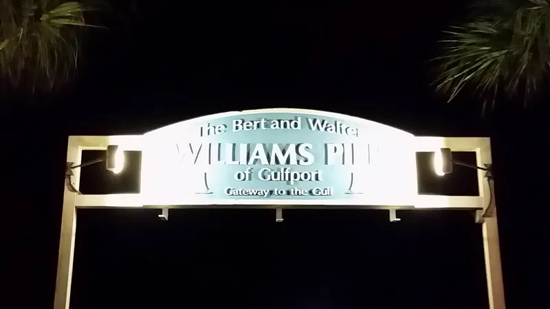 Lit Williams Pier entrance sign at night in Gulfport